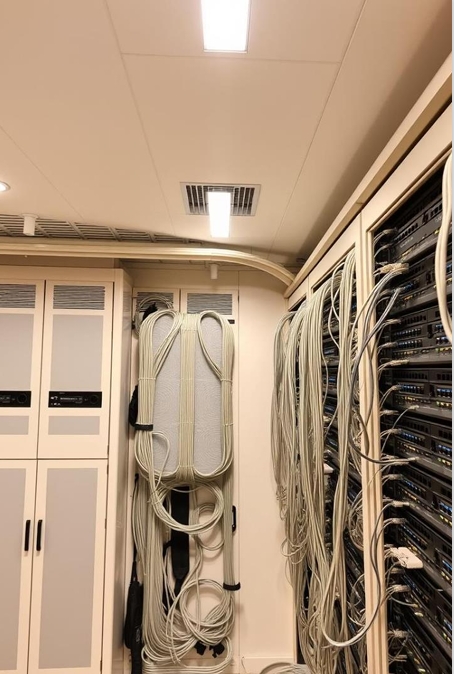 "IT engineers setting up server racks for enterprise-level network infrastructure."
